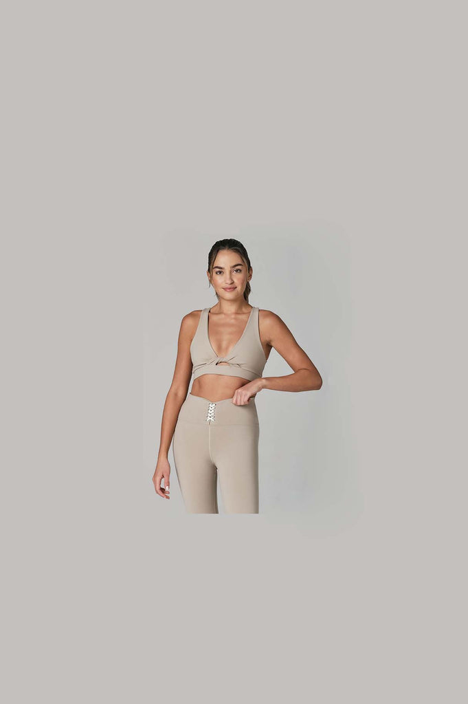 Woman wearing 925fit With a Twist sports bra and 4 Eva yoga pants designer activewear.