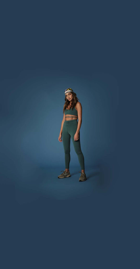 Woman wearing 925fit basil yoga pants and sports bra.