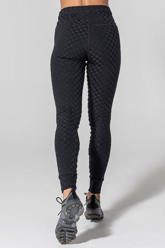 Woman is wearing 925 fit Welcome Ohm Black Jacquard yoga pants.