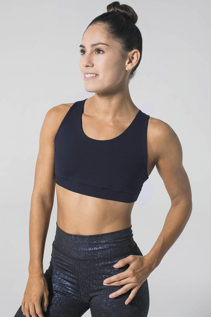 Woman is wearing 925 fit navy sports bra and navy yoga pants