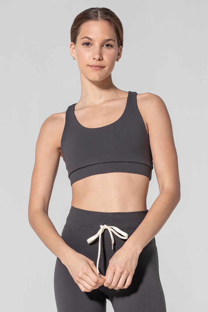 Woman is wearing 925 fit Get In Line Slate Racerback Sports Bra.