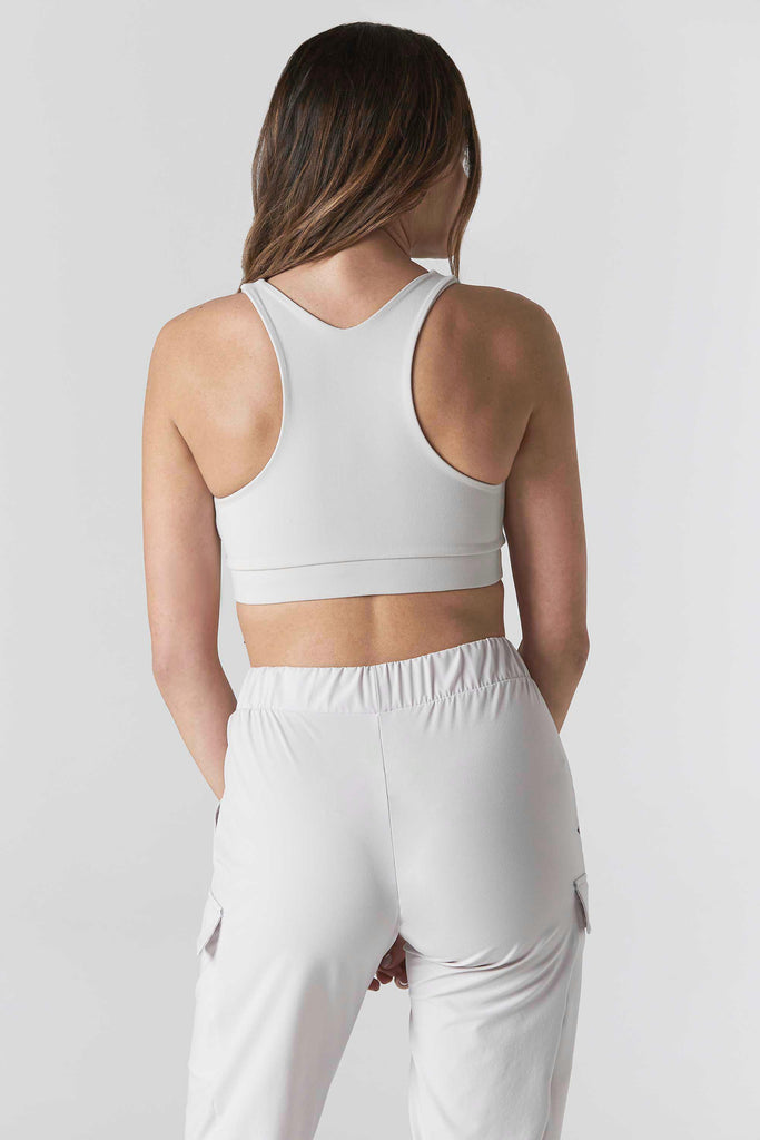 Woman is wearing 925 fit With a Twist Ash Racerback Sports Bra.