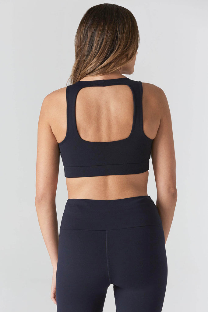 Woman is wearing 925 fit Fair & Square Navy Sports Bra.